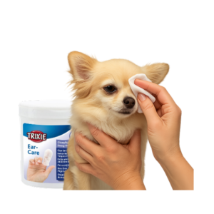 Persona limpiando el ojo de un perro pequeño con una toallita, junto a envase de toallitas Trixie Ear-Care para higiene ocular y auditiva.